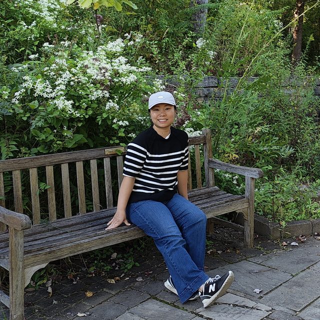 Teacher Penny relaxing on a bench in a Columbus park